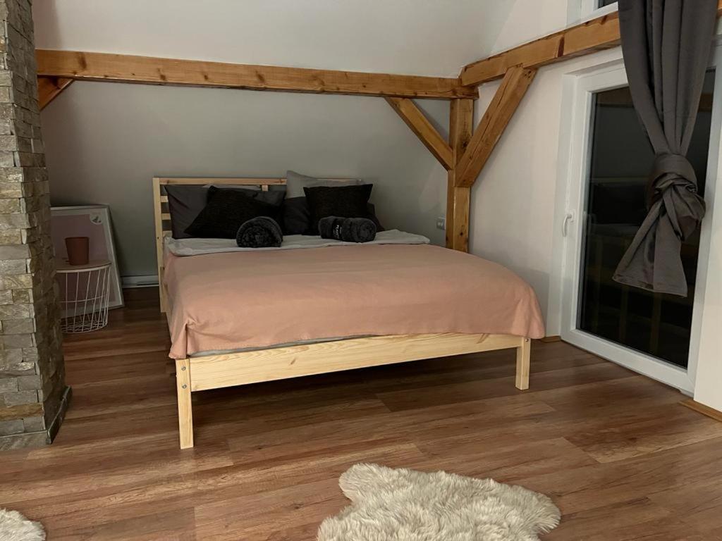 1 dormitorio con 1 cama grande con marco de madera en Vila Xenos Loft Karakter Zlatibor en Zlatibor