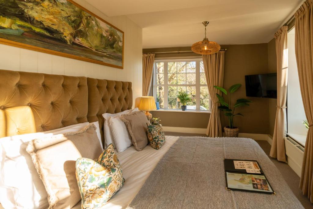 um quarto com uma cama grande e uma grande cabeceira. em Prince of Burford em Burford