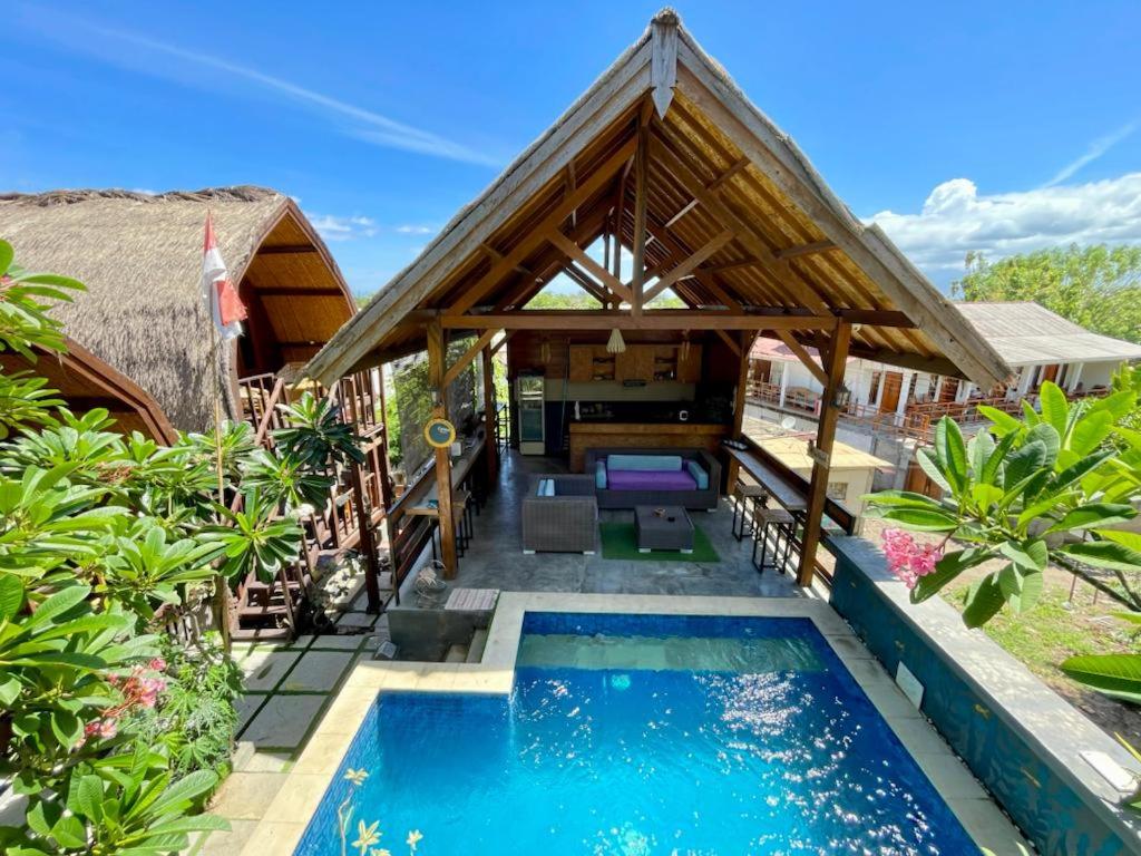 a villa with a swimming pool and a house at The golden Ave bungalow in Gili Trawangan