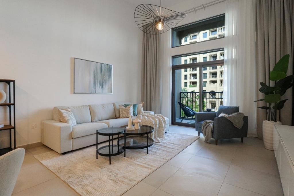 ein Wohnzimmer mit einem Sofa und einem Tisch in der Unterkunft HiGuests - Charming Modern Apartment Close To The Souk in MJL in Dubai