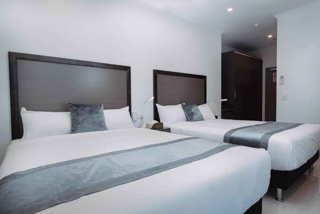 Ένα ή περισσότερα κρεβάτια σε δωμάτιο στο Darwin City Hotel