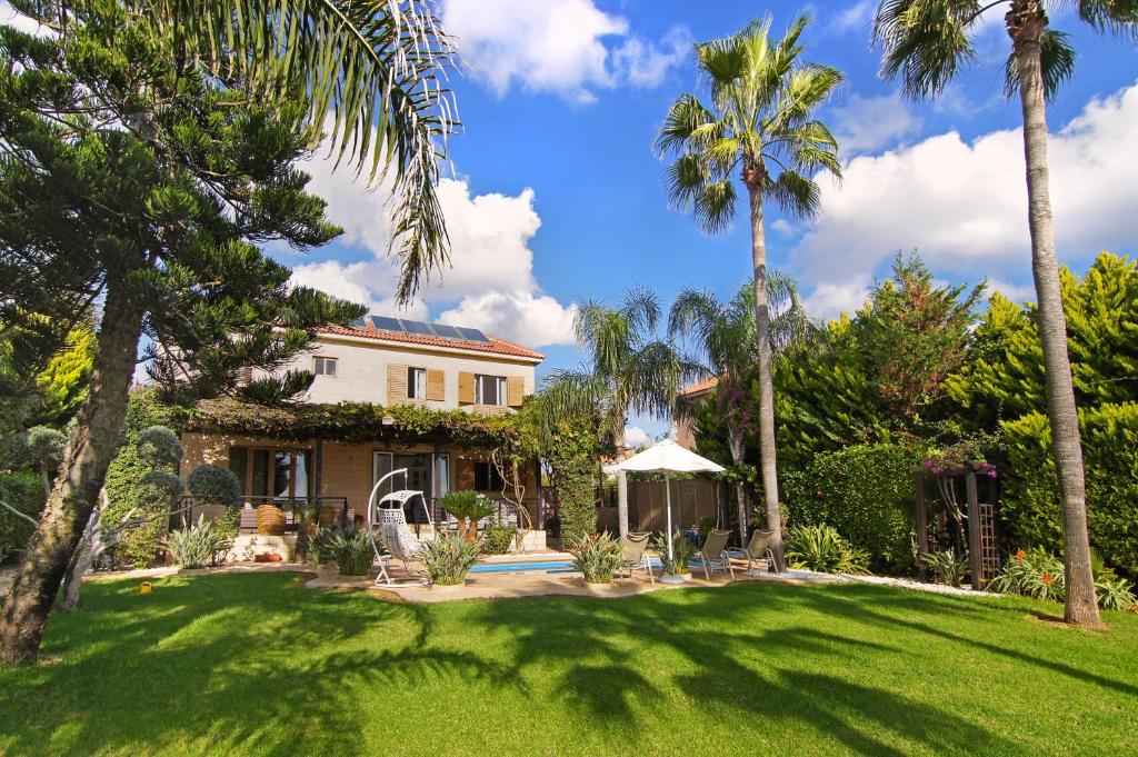 una casa con palmeras y un patio en Villa Polina, en Ayia Napa