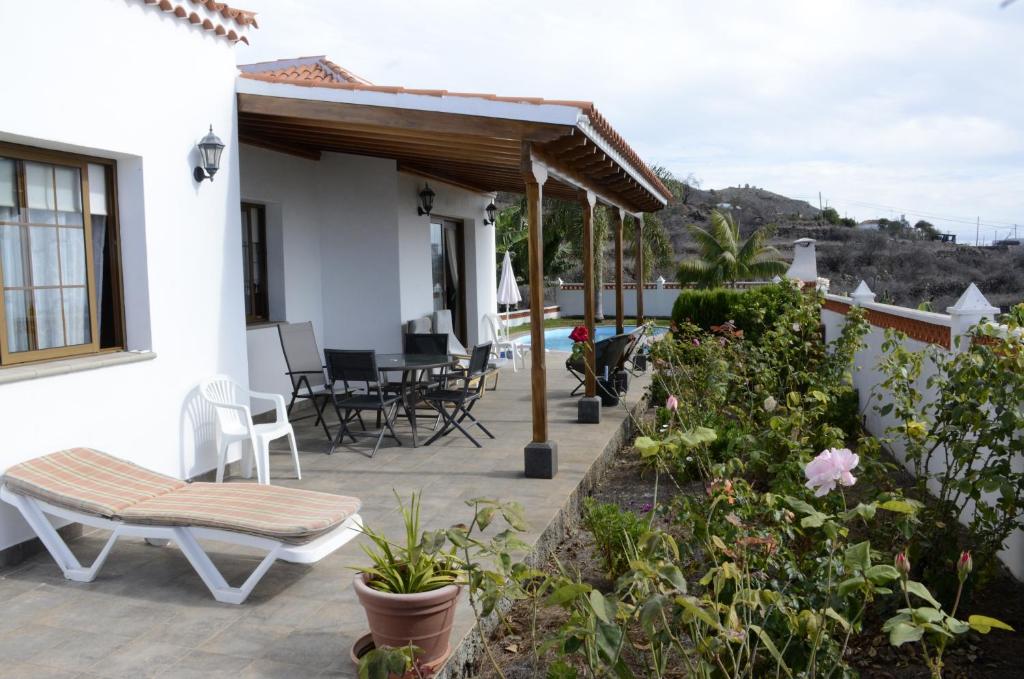 蒂哈拉費的住宿－Villa Estrella，一座带椅子和植物的庭院