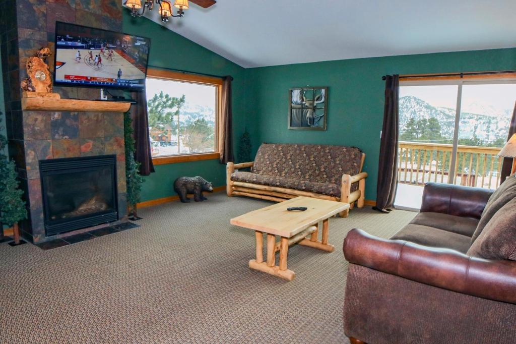ein Wohnzimmer mit einem Sofa und einem Kamin in der Unterkunft Rocky Mountain Retreat 1B by Rocky Mountain Resorts in Estes Park
