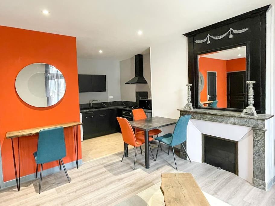 a living room with a table and chairs and a mirror at Joli appartement hyper-centre in Alençon