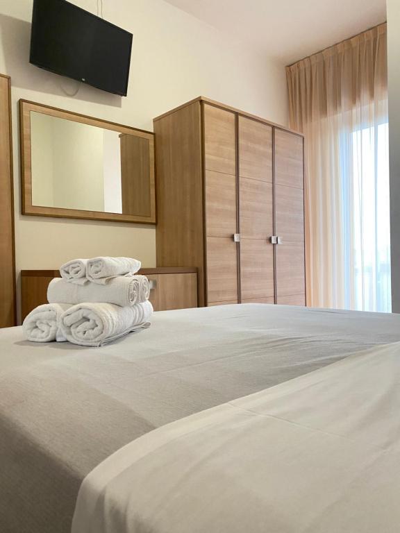 una camera da letto con un letto con tre asciugamani di Hotel Ravello da Lorenzo e Moira a Rimini