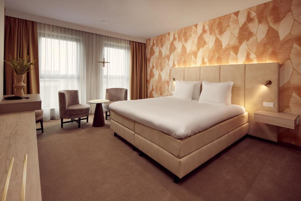 a hotel room with a large bed in a room at Van der Valk Hotel Gorinchem in Gorinchem