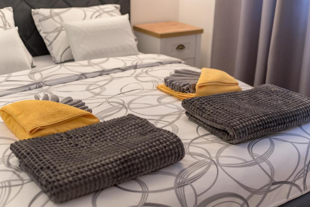 uma cama com duas almofadas em cima em Tanis Apartments em Niš