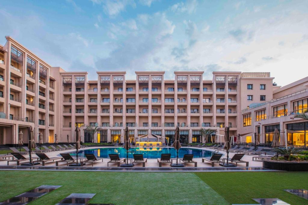 カイロにあるTriumph Luxury Hotelのプール付きの大きな建物の外観