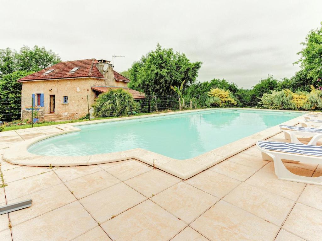 Villefranche-du-PérigordにあるSerene Holiday Home in Besse with Swimming Poolの家屋を背景にしたスイミングプール