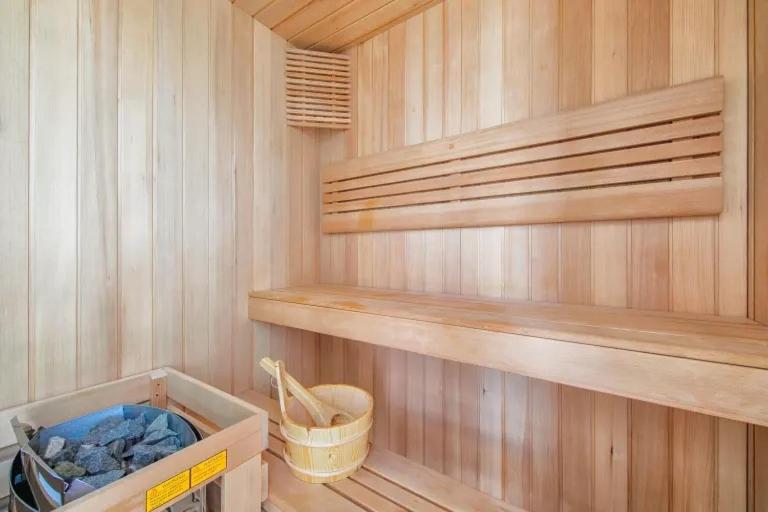 a small sauna with wooden shelves and a bucket at Villa Riviera Near Disneyland Paris in Chessy