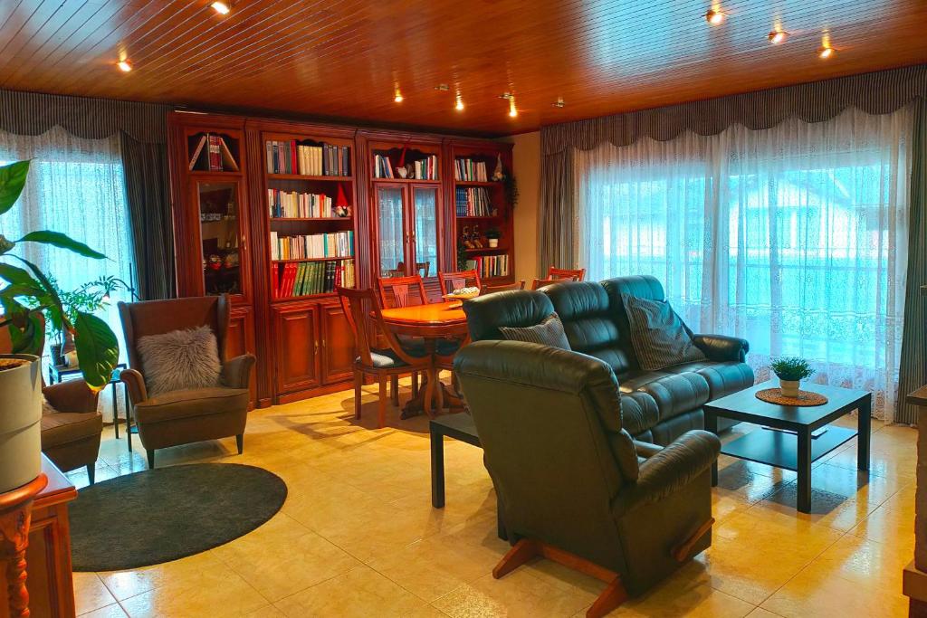 uma sala de estar com um sofá, uma mesa e cadeiras em Amplio ático con terraza en Andorra centro em Escaldes-Engordany