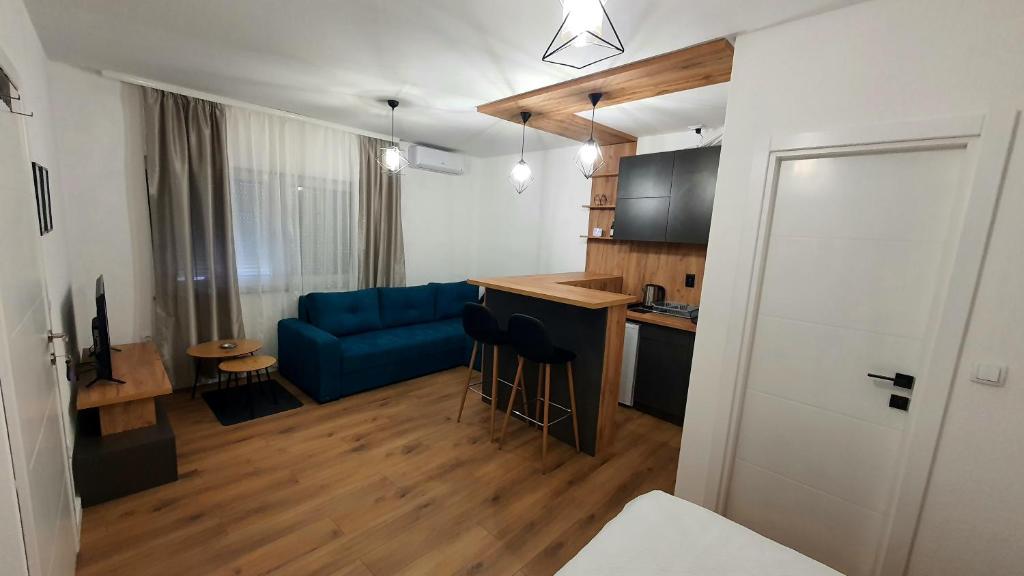 sala de estar con sofá azul y cocina en Apartman Campari en Banja Luka