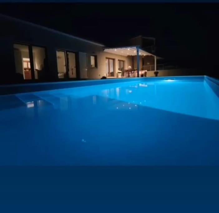 ein großer Pool in der Nacht mit blauer Beleuchtung in der Unterkunft Villa Theoma in Castelnuovo Magra