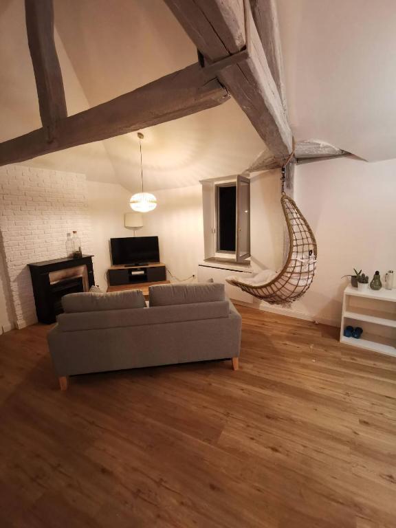 - un salon avec un canapé et une télévision dans l'établissement Le loft jeanne, à Orléans