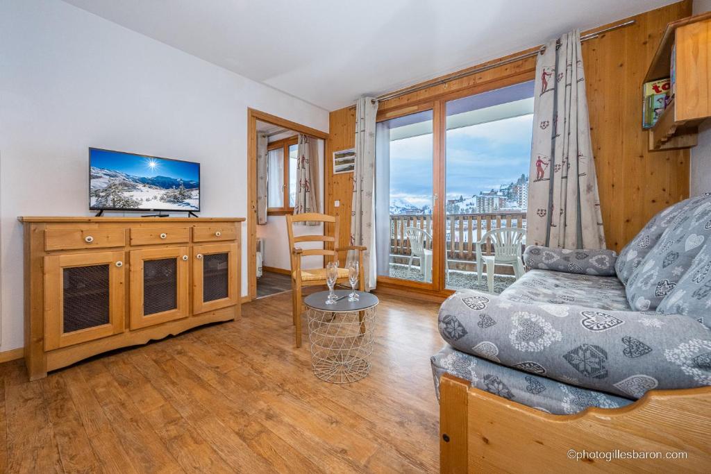 un salon avec un canapé et une télévision dans l'établissement B001- Appartement 2 pieces cabine 6 personnes, à Orcières