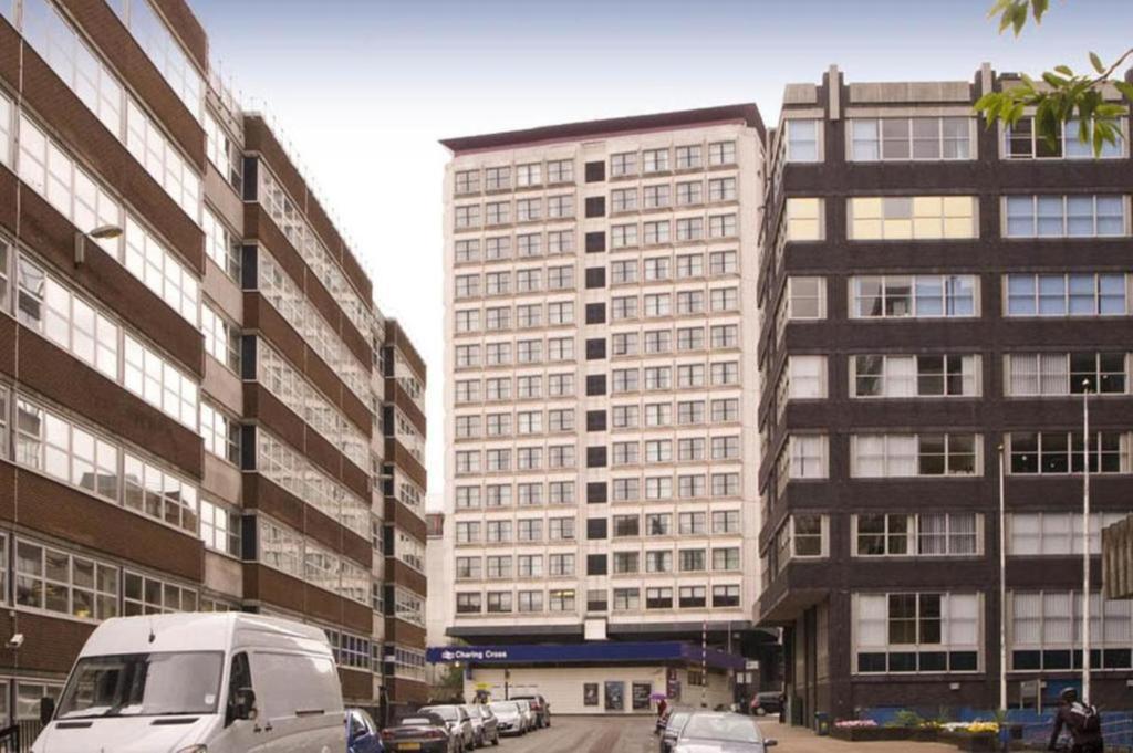 una furgoneta blanca estacionada frente a un edificio alto en Britannia Inn Glasgow, en Glasgow