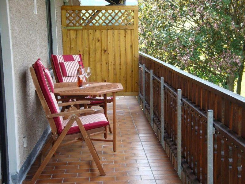eine Terrasse mit zwei Stühlen und einem Tisch auf einer Veranda in der Unterkunft Apartment Pahl in Wolfshagen