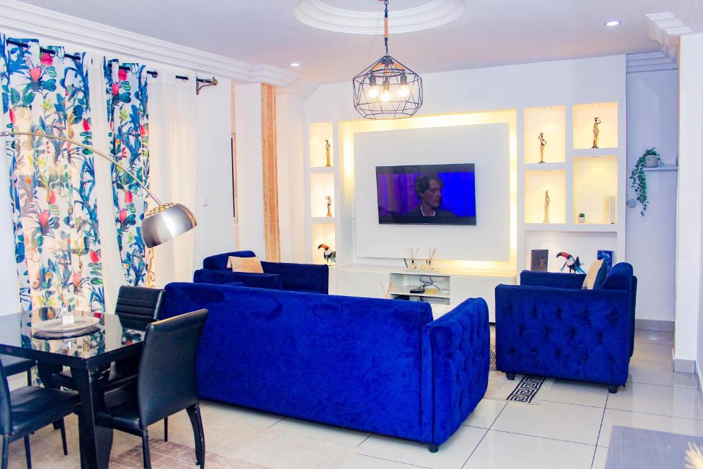 a living room with a blue couch and a table at Appartement cosy blue bonapriso in Douala