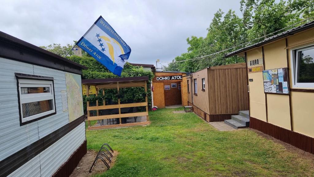 弗瓦迪斯瓦沃沃的住宿－Baza Turystyczna Atol，院子里一排带旗帜的房屋