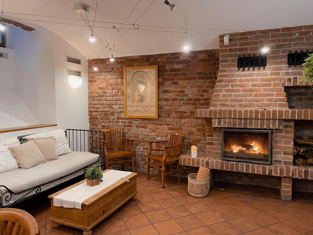 een woonkamer met een bakstenen muur en een open haard bij Prague apartment in Praag