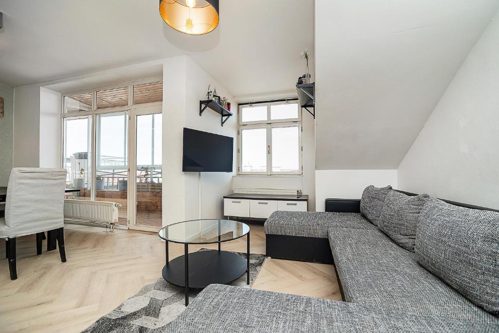 a living room with a couch and a table at Big 4-bedroom flat, terrace with great Vítkov view in Prague