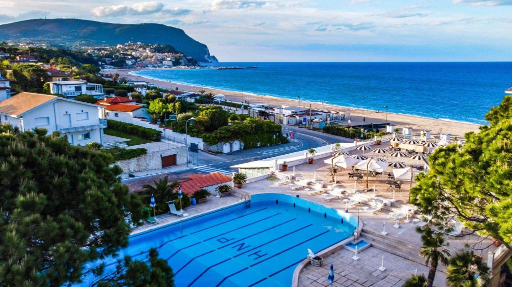 una piscina junto a una playa y el océano en Hotel Numana Palace, en Numana