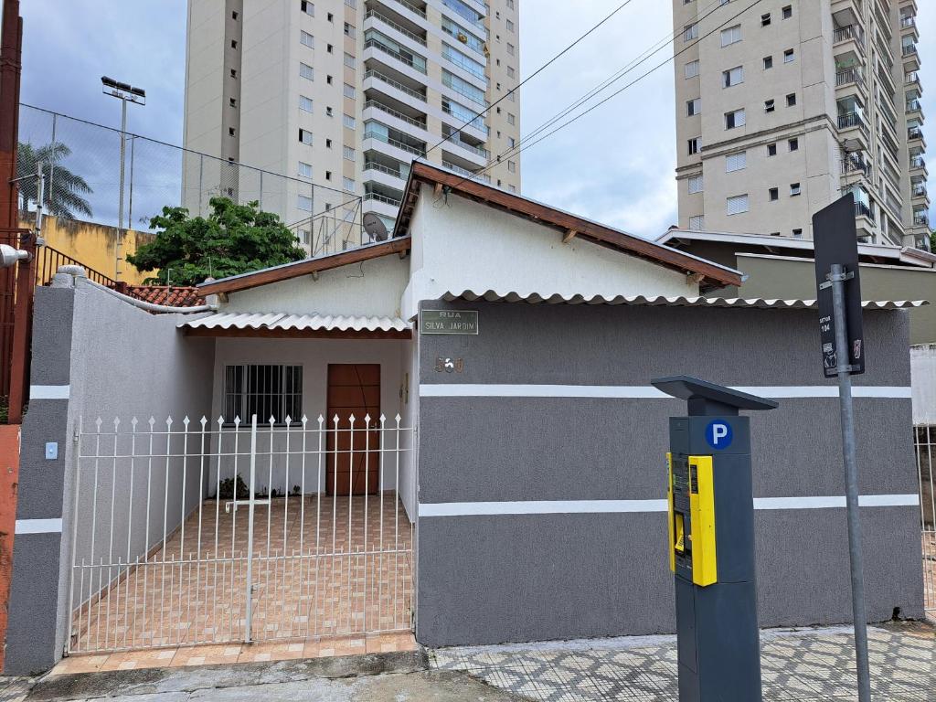 a small house with a fence and a parking meter at CASA LUGAR TOP - prefeitura, UNITAU, hospital e Av do Povo in Taubaté