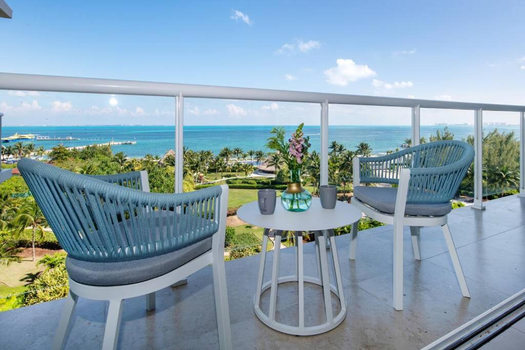duas cadeiras e uma mesa numa varanda com o oceano em Amara, depa con vista al mar em Cancún