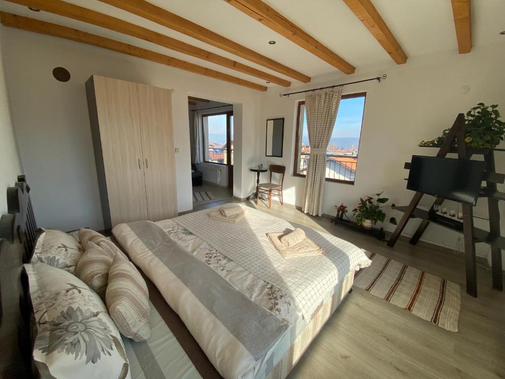 um quarto com uma cama grande num quarto com uma janela em Стаи за гости Дима em Bansko