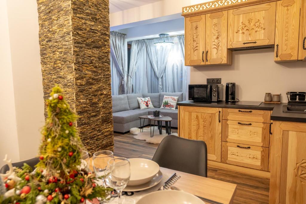 a kitchen and living room with a christmas tree on a table at Modrzewiowa Ostoja II in Kluszkowce