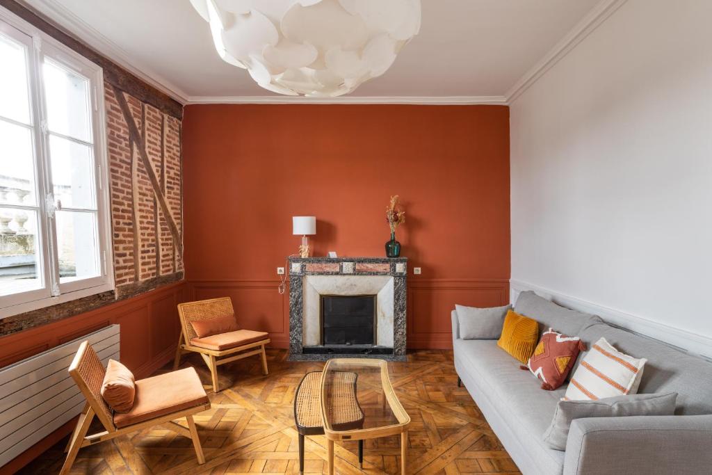 un salon avec un canapé et une cheminée dans l'établissement Le Cambronne - en Bail Mobilité, à Nantes