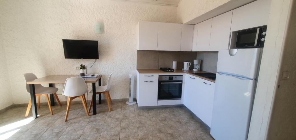 a small kitchen with a table and a white refrigerator at I Casetti in Molini