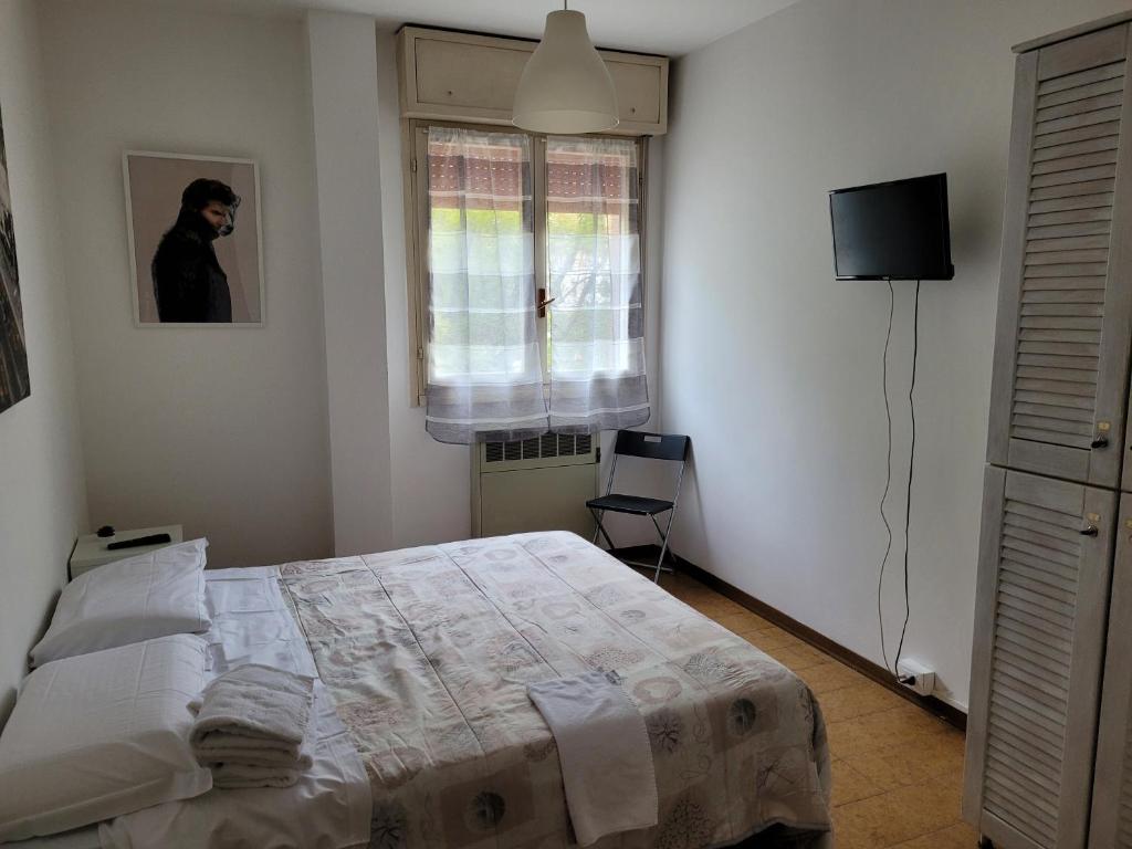 Schlafzimmer mit einem Bett und einem Fenster in der Unterkunft Room Pappagnocca in Reggio nell'Emilia