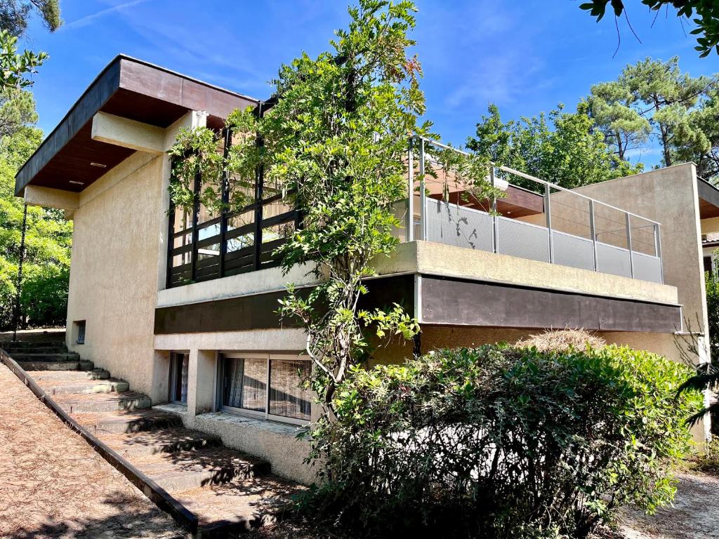 un bâtiment avec un balcon sur le côté dans l'établissement Le Bonheur en Vacances ! :), à Lacanau