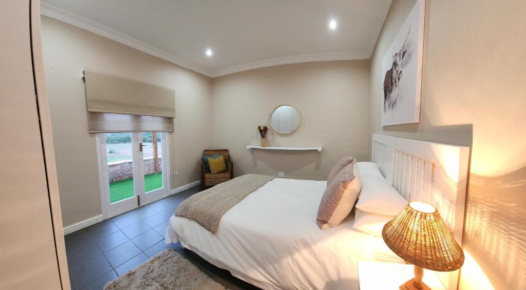 Un dormitorio con una cama grande y una ventana. en Bon Game Reserve, en Blandʼs Drift