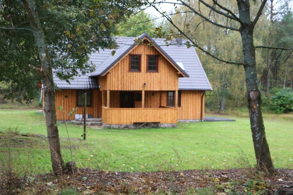 une maison en bois au milieu d'un champ dans l'établissement Klasztor 5 Borowy Mlyn, à Lipnica