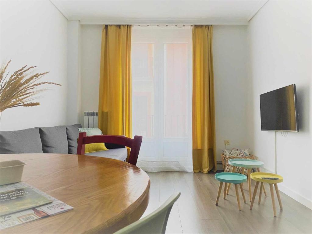 sala de estar con mesa de madera y sillas en Apartamento Ayla Camino de Santiago, en Pamplona