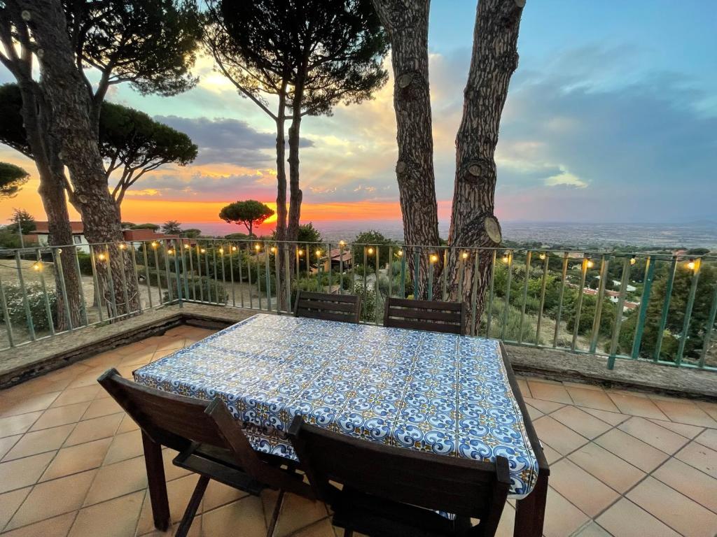 een tafel en stoelen op een balkon met een zonsondergang bij Appartamento castelli Romani - con vista su ROMA in Monte Porzio Catone