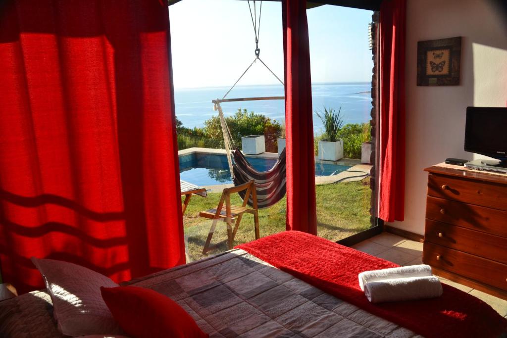 1 dormitorio con ventana y vistas al océano en Hogar del Viento, Piscina Privada y Vista panorámica al Mar, en Piriápolis