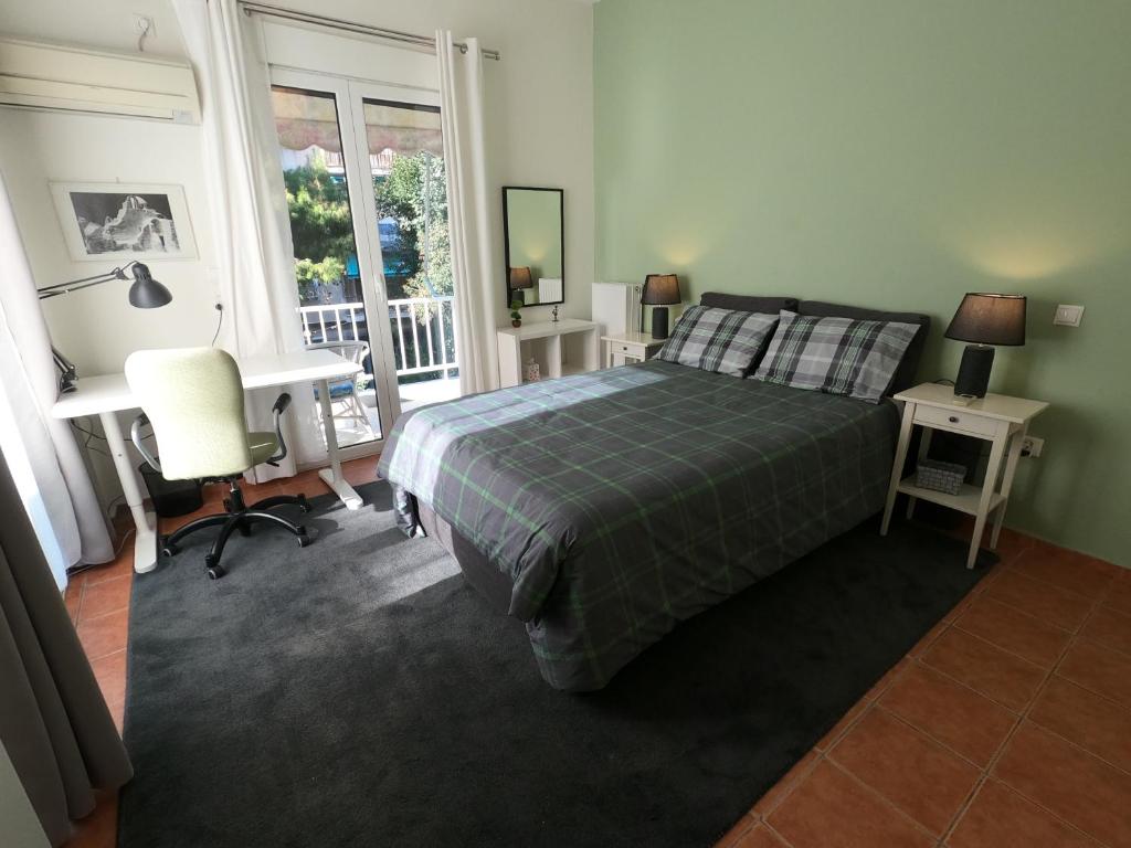 a bedroom with a bed and a desk and a window at Park view apartment near Panormou in Athens