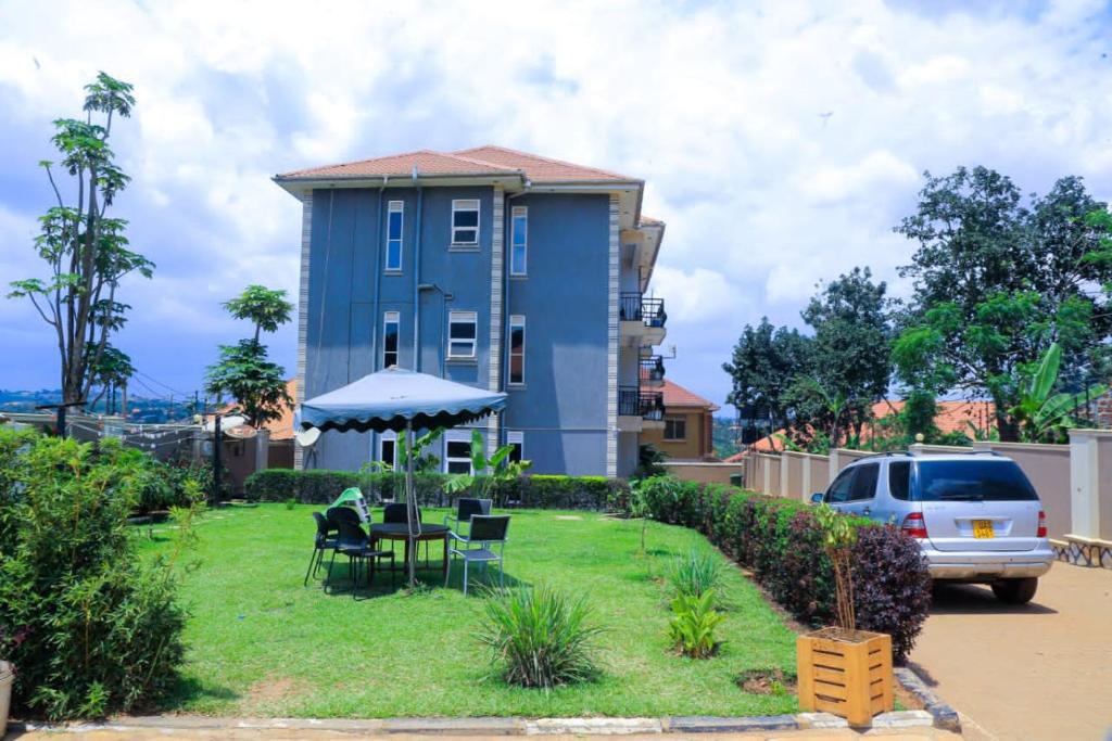 a blue house with a table and chairs in a yard at Karibu Namugongo in Kampala