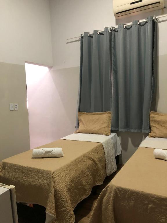 a room with two beds and a window at Ágape Hotel in Rio Verde