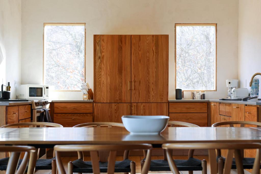 a kitchen with two tables and chairs and two windows at The Edelweiss Estate in Gatlinburg