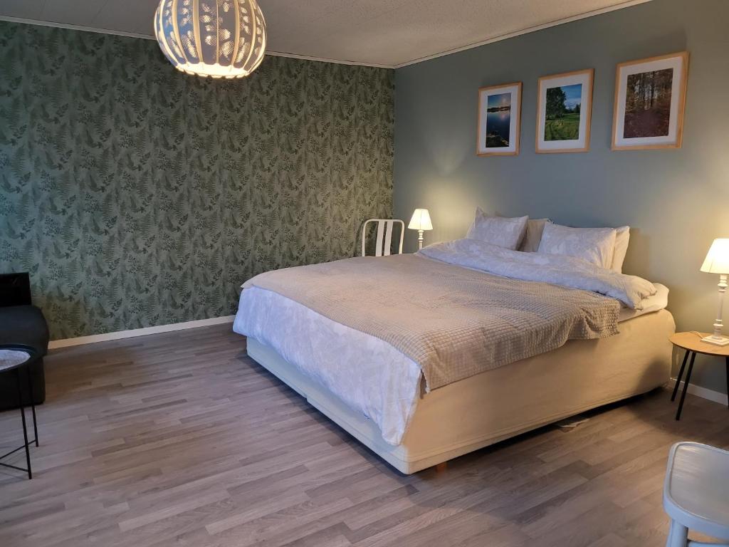 1 dormitorio con cama y lámpara de araña en Bokskogens Guesthouse en Kulltorp
