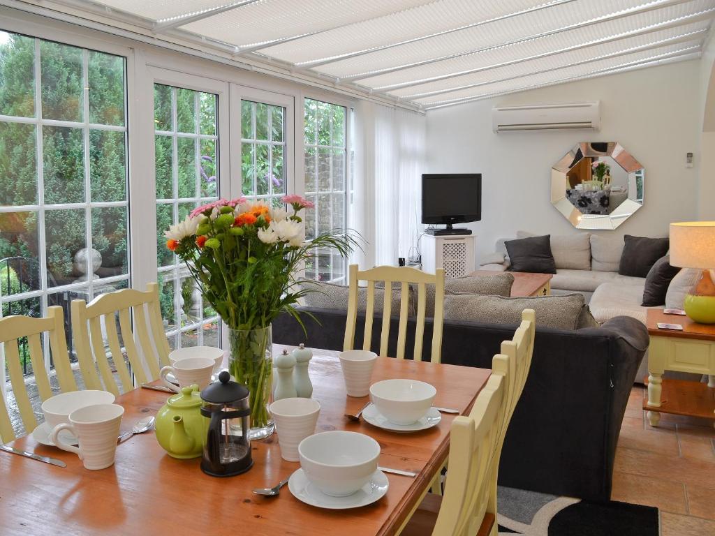 a living room with a wooden table with flowers on it at The Orangery in Bideford