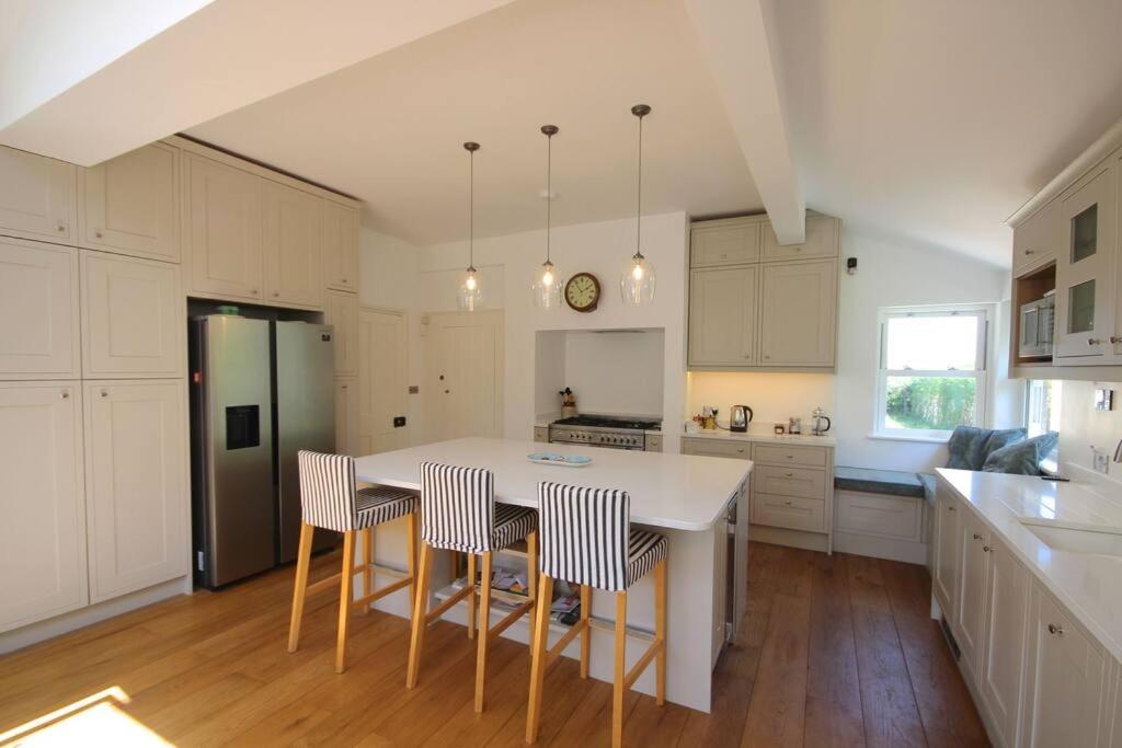a kitchen with a table and chairs and a refrigerator at Downsview in Kingsdown