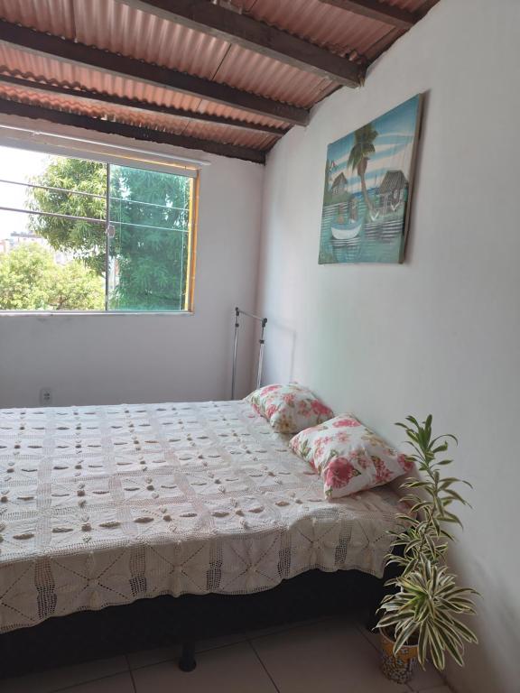 1 dormitorio con 1 cama con 2 almohadas y ventana en CACTUS KIT NET, en Salvador