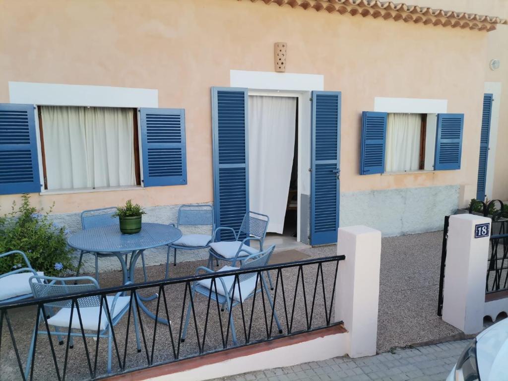 a balcony with blue shutters and a table and chairs at Sa caseta des port in Banyalbufar