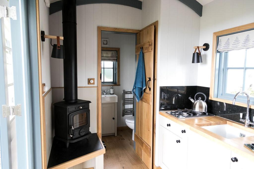 a kitchen with a wood stove in a kitchen at Skylark Shepherds Hut in Bath
